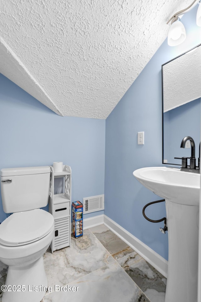 3106 Ramser Ave, Louisville, KY 40216 - half bath with a textured ceiling, lofted ceiling, and marble look tiles
