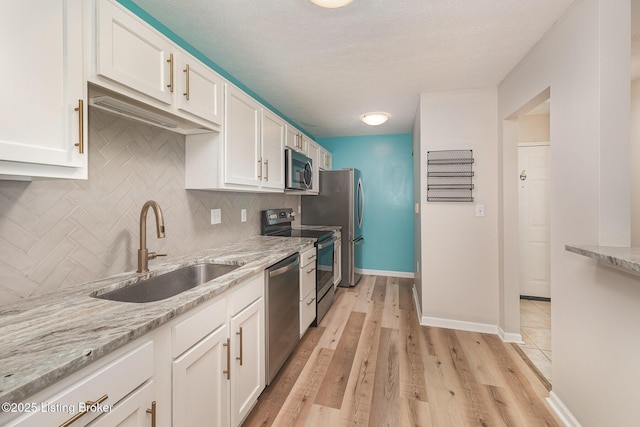 10304 Southern Meadows Dr Unit 101, Louisville, KY 40241 - kitchen with stainless steel appliances, a sink, white cabinets, backsplash, and light stone countertops