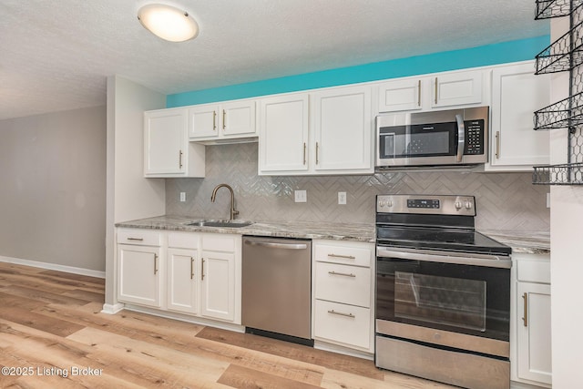 10304 Southern Meadows Dr Unit 101, Louisville, KY 40241 - kitchen featuring stainless steel appliances, a sink, white cabinets, backsplash, and a textured ceiling