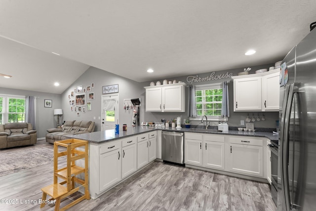 987 Wheelers Mill Rd, Munfordville, KY 42765 - kitchen featuring stainless steel appliances, a peninsula, a sink, light wood-style floors, and white cabinets
