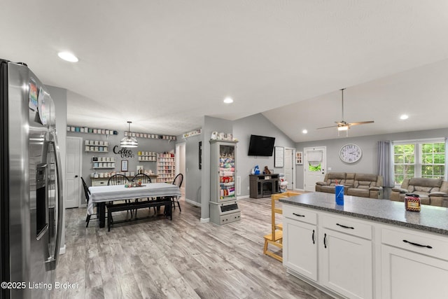 987 Wheelers Mill Rd, Munfordville, KY 42765 - kitchen with stainless steel fridge, white cabinetry, open floor plan, a ceiling fan, and vaulted ceiling