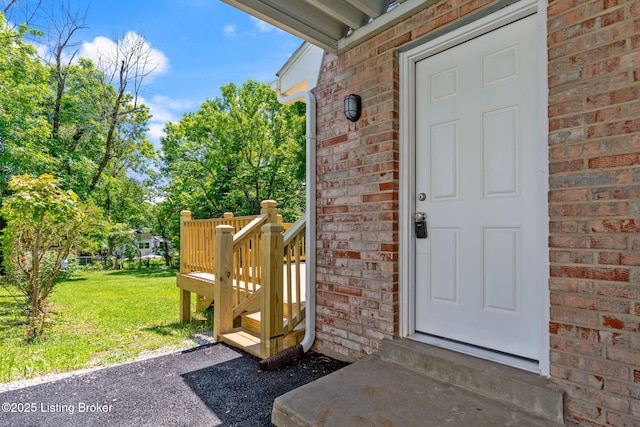 10518 Fairview Ave, Louisville, KY 40299 - view of exterior entry with brick siding, a lawn, and a wooden deck