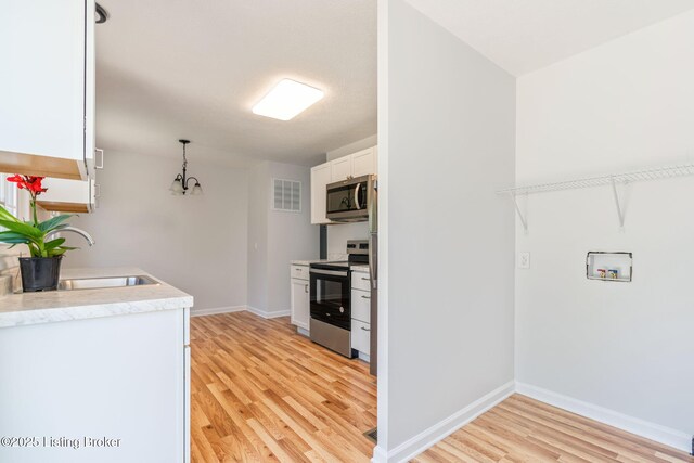 10518 Fairview Ave, Louisville, KY 40299 - kitchen with stainless steel appliances, a sink, light wood-style floors, white cabinets, and light countertops