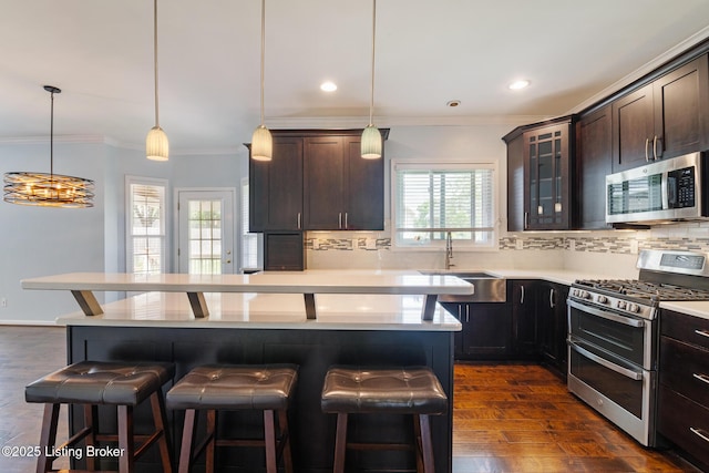 3613 Wynbrooke Cir, Louisville, KY 40241 - kitchen featuring stainless steel appliances, a sink, a kitchen bar, decorative backsplash, and crown molding