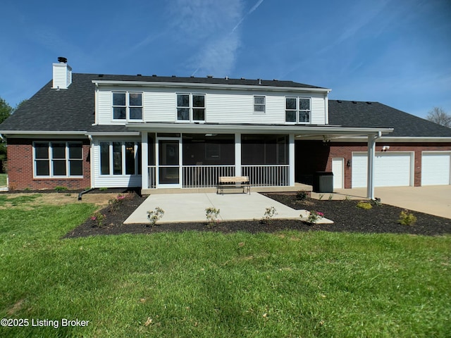 5101 Elm Tree Pl, Louisville, KY 40299 - back of house featuring brick siding, a chimney, a yard, driveway, and an attached garage