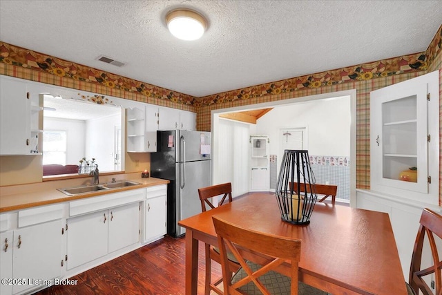 8400 Wisertown Rd, Louisville, KY 40214 - kitchen with freestanding refrigerator, a sink, wallpapered walls, a textured ceiling, and dark wood-style flooring