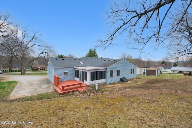 8400 Wisertown Rd, Louisville, KY 40214 - rear view of house featuring a sunroom, a shingled roof, a lawn, and a wooden deck