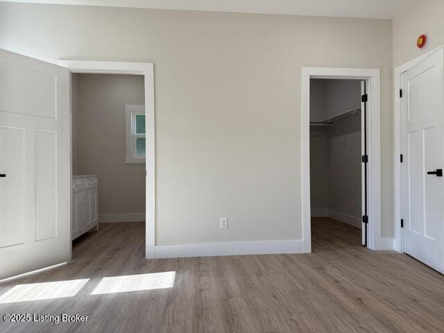 49 Roy Rd, Eastview, KY 42732 - unfurnished bedroom with wood finished floors, a spacious closet, baseboards, and a closet