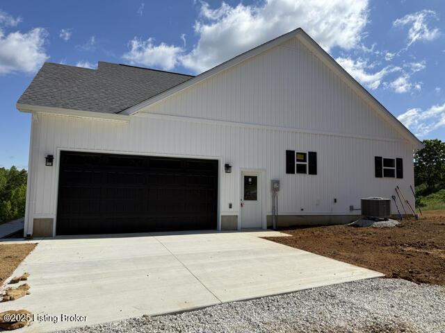 49 Roy Rd, Eastview, KY 42732 - view of side of home featuring driveway, a garage, central AC, and a shingled roof