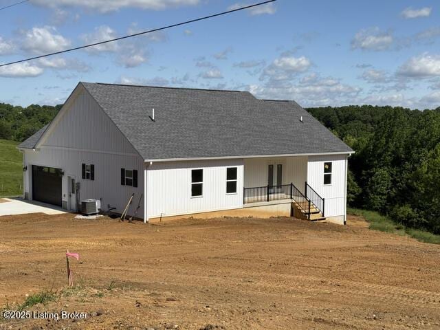 49 Roy Rd, Eastview, KY 42732 - rear view of property featuring central air condition unit, a shingled roof, an attached garage, and concrete driveway