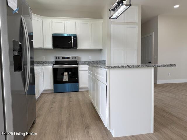 49 Roy Rd, Eastview, KY 42732 - kitchen featuring appliances with stainless steel finishes, light wood-style flooring, a kitchen island, white cabinets, and light stone countertops