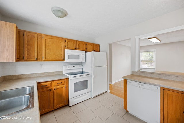 265 N Steedland Dr, Shepherdsville, KY 40229 - kitchen featuring white appliances, light countertops, a sink, light tile patterned floors, and brown cabinetry