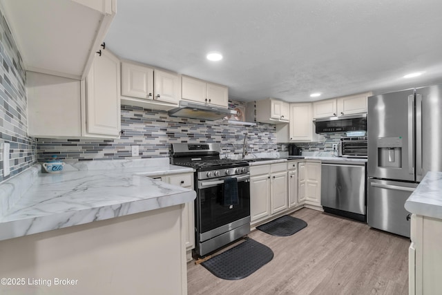 4328 Dohn Ave, Louisville, KY 40216 - kitchen featuring appliances with stainless steel finishes, under cabinet range hood, backsplash, light wood-style floors, and recessed lighting