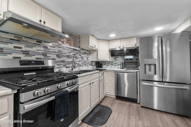 4328 Dohn Ave, Louisville, KY 40216 - kitchen featuring stainless steel appliances, exhaust hood, tasteful backsplash, light wood finished floors, and light countertops