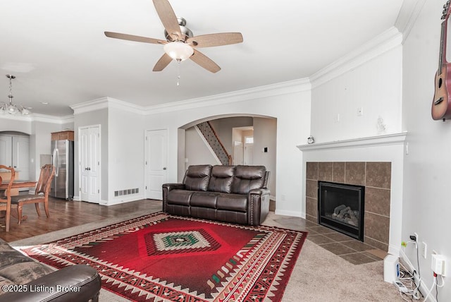 9006 Big Boulder Dr, Louisville, KY 40291 - living room featuring crown molding, arched walkways, a ceiling fan, a fireplace, and baseboards
