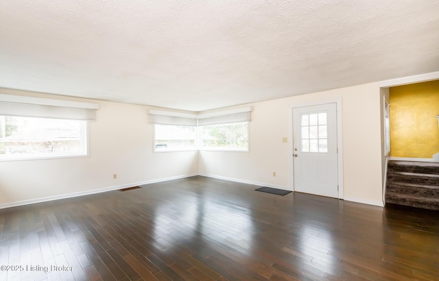 1031 Thruston Ave, Louisville, KY 40217 - unfurnished living room featuring stairway, a textured ceiling, baseboards, and wood finished floors