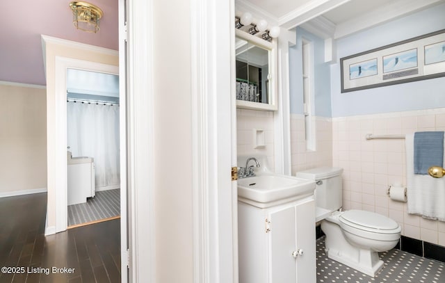 1031 Thruston Ave, Louisville, KY 40217 - full bath with tile walls, vanity, toilet, wood finished floors, and a wainscoted wall