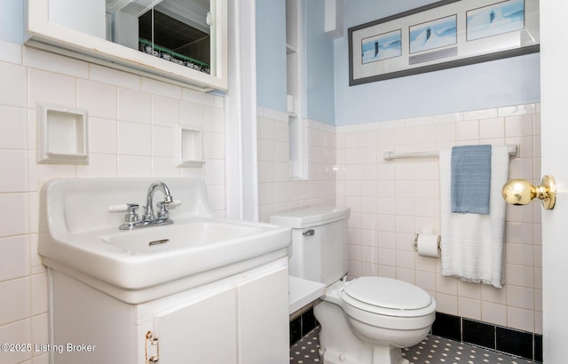 1031 Thruston Ave, Louisville, KY 40217 - half bath featuring tile walls, toilet, vanity, and tile patterned flooring
