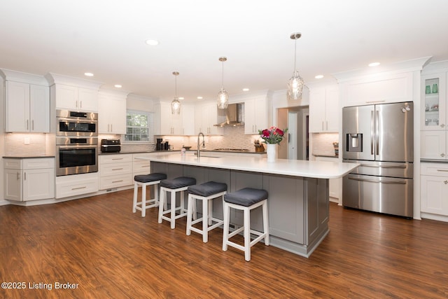 2401 Branning Rd, Thornhill, KY 40222 - kitchen featuring stainless steel appliances, wall chimney exhaust hood, a sink, a kitchen bar, and white cabinetry