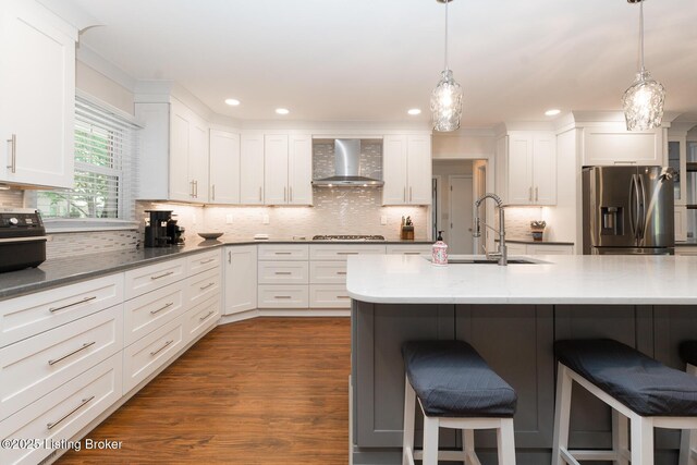 2401 Branning Rd, Thornhill, KY 40222 - kitchen with wall chimney range hood, stainless steel fridge, a sink, a breakfast bar area, and white cabinets