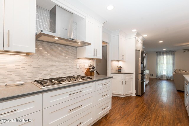 2401 Branning Rd, Thornhill, KY 40222 - kitchen with wall chimney exhaust hood, appliances with stainless steel finishes, white cabinetry, dark wood-style flooring, and decorative backsplash