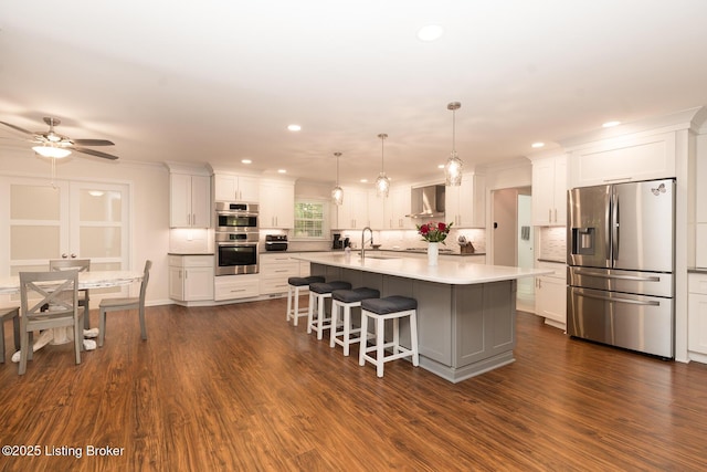 2401 Branning Rd, Thornhill, KY 40222 - kitchen featuring appliances with stainless steel finishes, wall chimney range hood, a sink, white cabinets, and backsplash