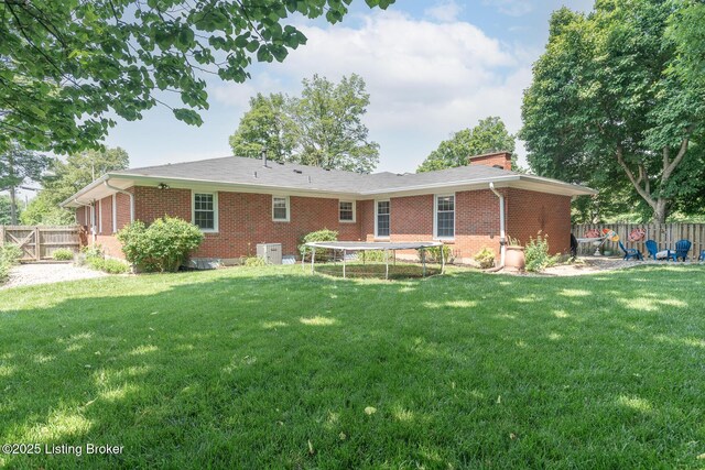 2401 Branning Rd, Thornhill, KY 40222 - back of property featuring a trampoline, brick siding, a chimney, and central air condition unit