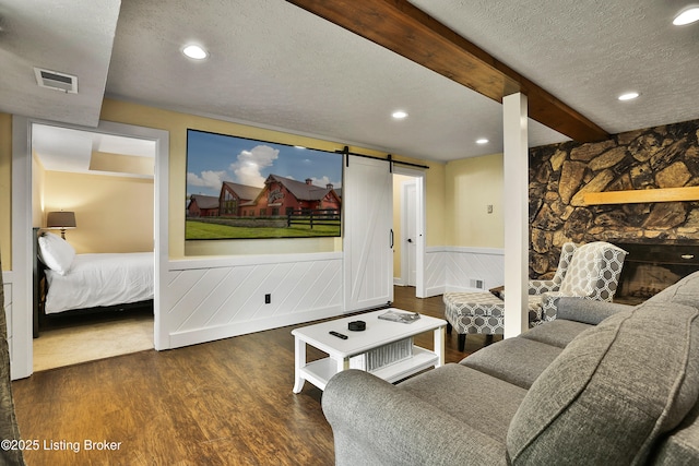 1416 Taylor Wood Rd, Simpsonville, KY 40067 - living area with a textured ceiling, a barn door, a wainscoted wall, wood finished floors, and beam ceiling
