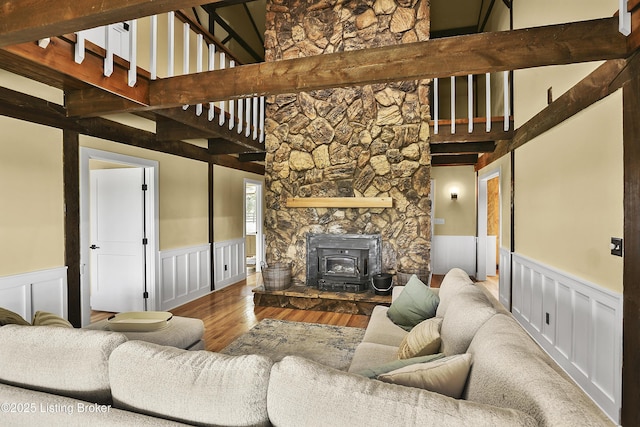 1416 Taylor Wood Rd, Simpsonville, KY 40067 - living room with a wainscoted wall, a wood stove, wood finished floors, a decorative wall, and a towering ceiling