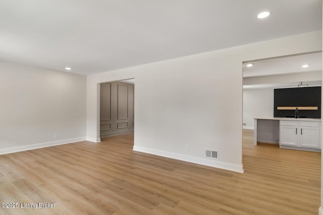 4205 Cottagehill Rd, Louisville, KY 40299 - unfurnished living room with baseboards, light wood-style flooring, recessed lighting, and a sink