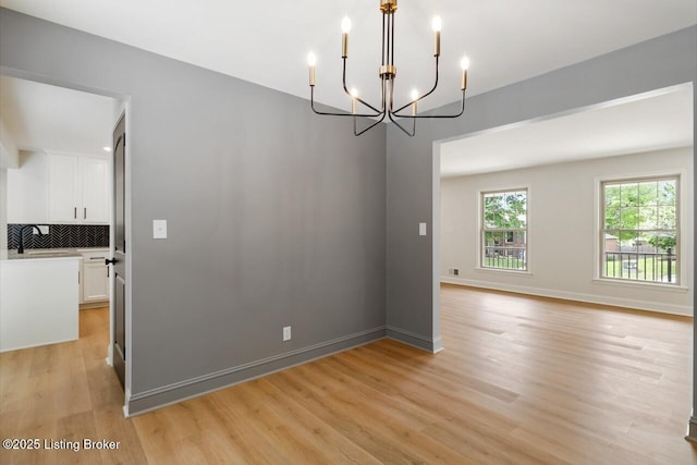 4205 Cottagehill Rd, Louisville, KY 40299 - spare room with a chandelier, light wood-type flooring, and baseboards
