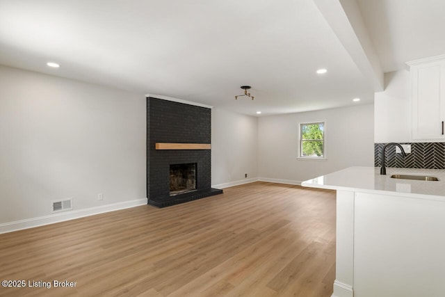 4205 Cottagehill Rd, Louisville, KY 40299 - unfurnished living room with a sink, light wood-type flooring, recessed lighting, a fireplace, and baseboards