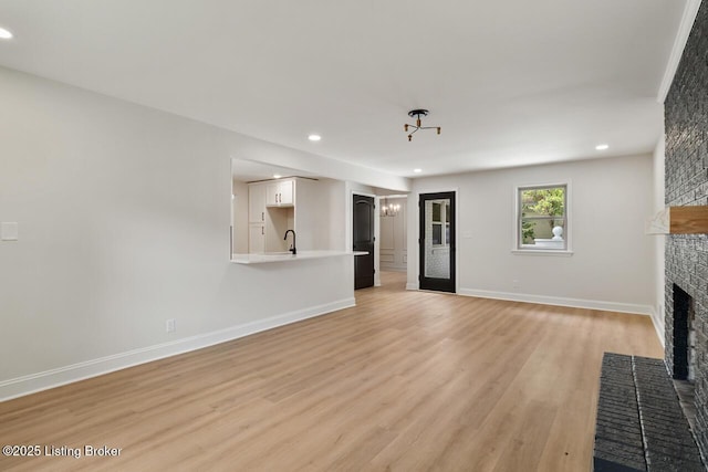 4205 Cottagehill Rd, Louisville, KY 40299 - unfurnished living room with a brick fireplace, a sink, light wood finished floors, recessed lighting, and baseboards