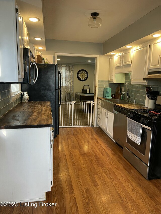 2623 Parklawn Dr, Louisville, KY 40217 - kitchen with stainless steel appliances, white cabinets, a sink, backsplash, and wood counters