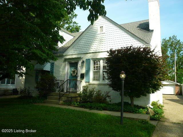 1411 Falcon Dr, Louisville, KY 40213 - view of front of home featuring a chimney, a front yard, and an outbuilding