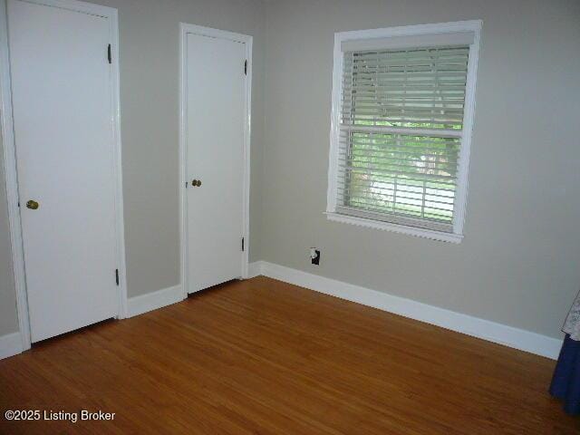 1411 Falcon Dr, Louisville, KY 40213 - unfurnished bedroom featuring wood finished floors and baseboards