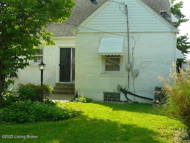 1411 Falcon Dr, Louisville, KY 40213 - back of property with a shingled roof, entry steps, and a lawn