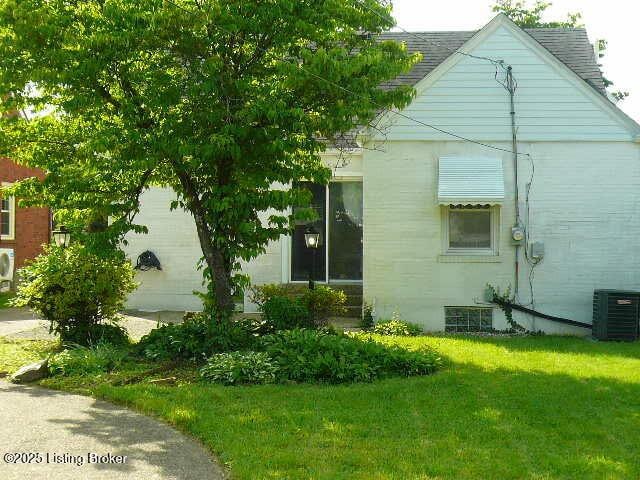1411 Falcon Dr, Louisville, KY 40213 - view of side of property featuring a yard, central air condition unit, and a shingled roof
