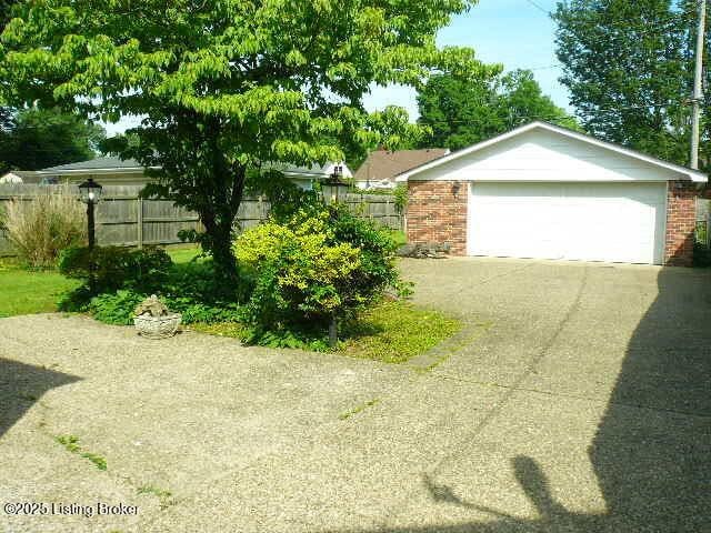 1411 Falcon Dr, Louisville, KY 40213 - view of home's exterior featuring brick siding and a garage