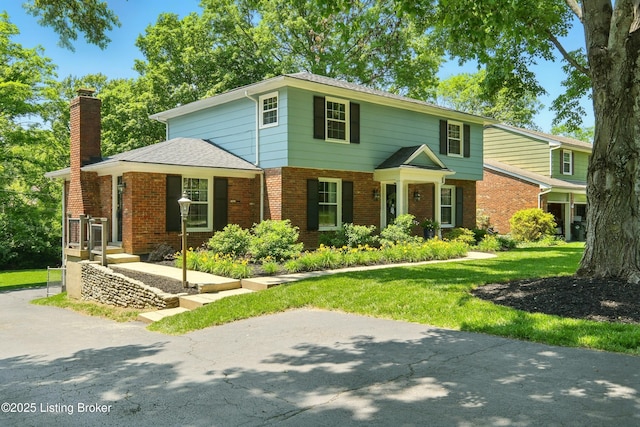 828 Dorsey Ln, Louisville, KY 40223 - view of front facade with brick siding, a chimney, and a front yard