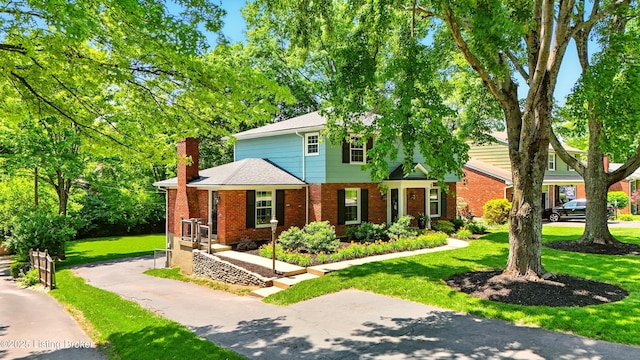 828 Dorsey Ln, Louisville, KY 40223 - view of front of house featuring brick siding, a front lawn, a chimney, and roof with shingles