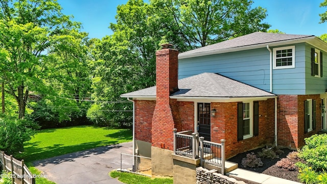 828 Dorsey Ln, Louisville, KY 40223 - view of home's exterior featuring a chimney, a shingled roof, and brick siding