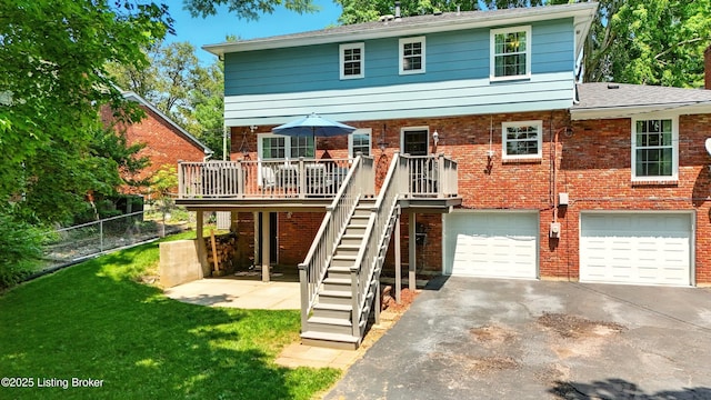 828 Dorsey Ln, Louisville, KY 40223 - back of house featuring asphalt driveway, stairs, an attached garage, a deck, and brick siding