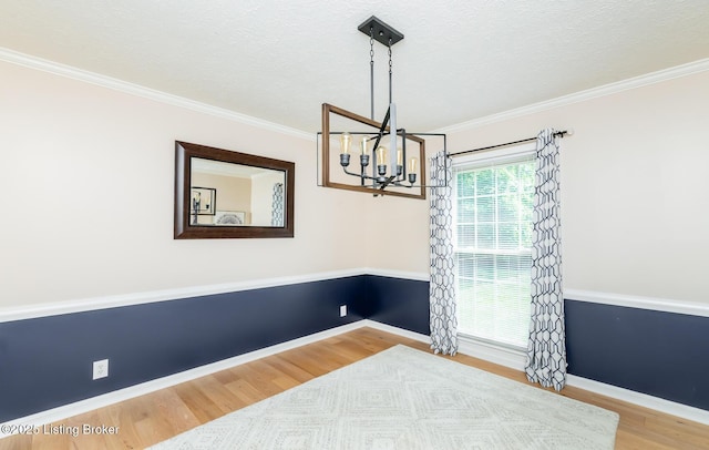 1311 Pollitt Ct, Louisville, KY 40223 - spare room featuring a chandelier, wood finished floors, crown molding, a textured ceiling, and baseboards