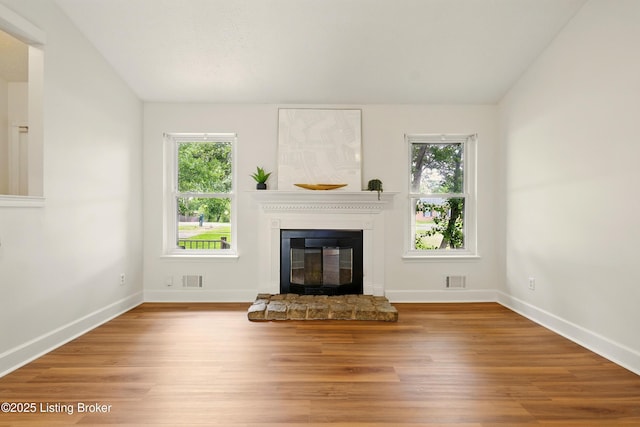 5115 Stony Brook Dr, Louisville, KY 40291 - unfurnished living room featuring healthy amount of natural light, a glass covered fireplace, lofted ceiling, wood finished floors, and baseboards