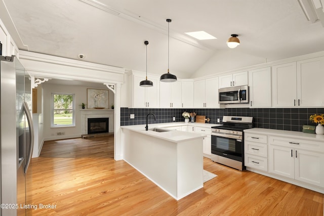 5115 Stony Brook Dr, Louisville, KY 40291 - kitchen featuring stainless steel appliances, a sink, white cabinetry, light wood-type flooring, and decorative backsplash