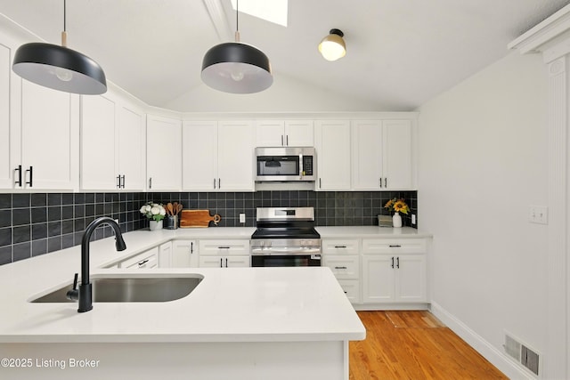 5115 Stony Brook Dr, Louisville, KY 40291 - kitchen with appliances with stainless steel finishes, a sink, tasteful backsplash, vaulted ceiling, and light wood-type flooring