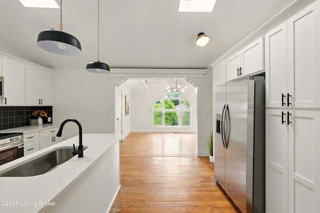 5115 Stony Brook Dr, Louisville, KY 40291 - kitchen with stainless steel fridge, a sink, a skylight, and white cabinets