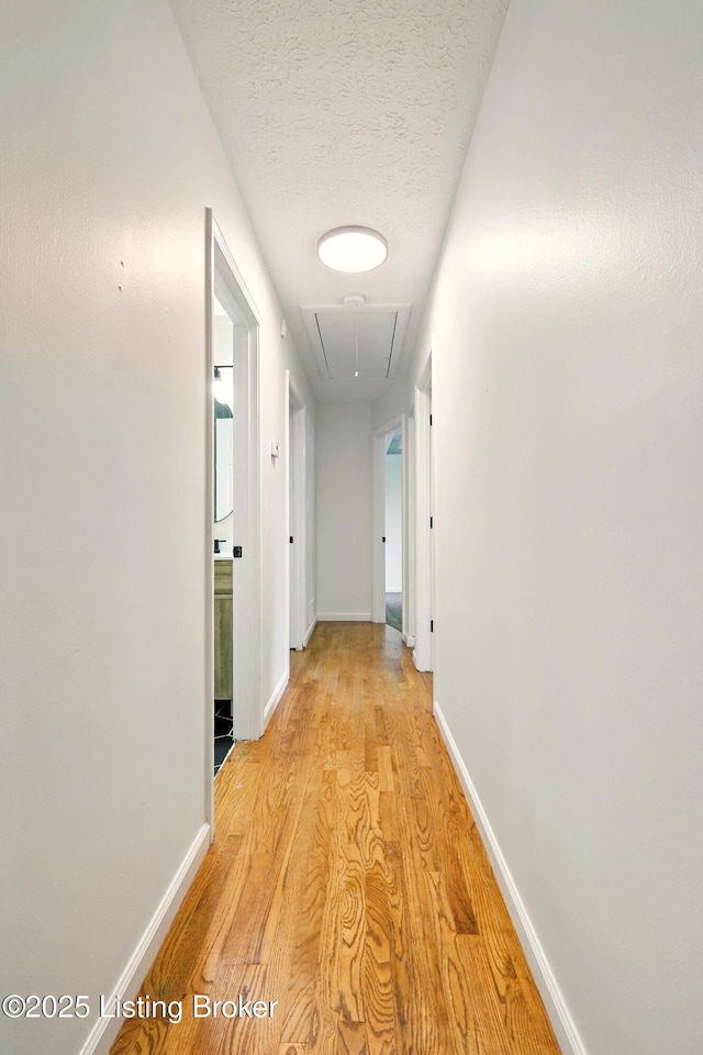 5115 Stony Brook Dr, Louisville, KY 40291 - corridor featuring attic access, light wood-style floors, a textured ceiling, and baseboards