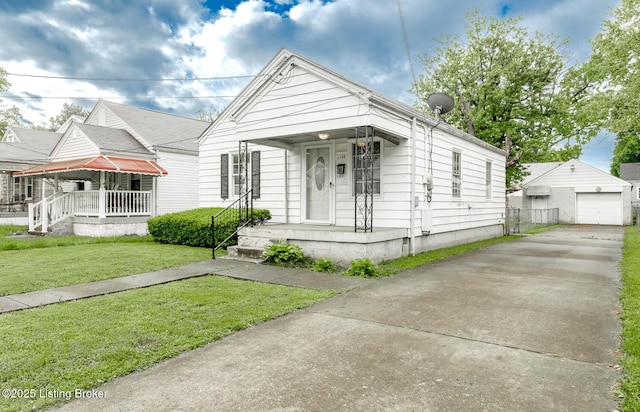 1108 Dresden Ave, Louisville, KY 40215 - shotgun-style home with a front lawn, covered porch, concrete driveway, and an outbuilding